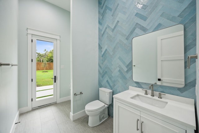 bathroom with vanity, toilet, tile walls, and tile patterned flooring