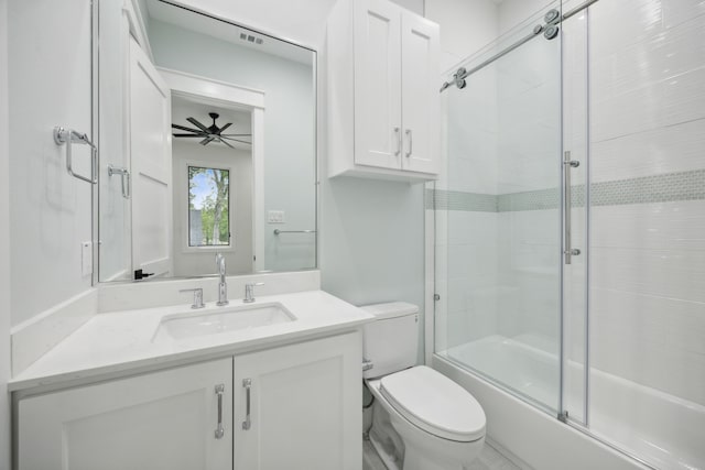 full bathroom featuring vanity, toilet, enclosed tub / shower combo, and ceiling fan