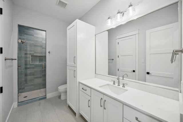 bathroom with toilet, a shower with shower door, and vanity