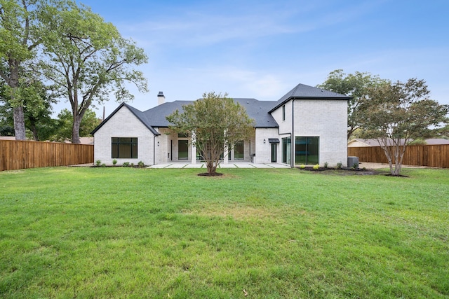 rear view of house featuring a yard, a patio area, and central AC unit