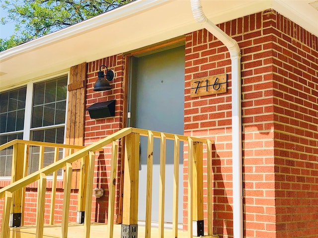 view of exterior entry featuring brick siding