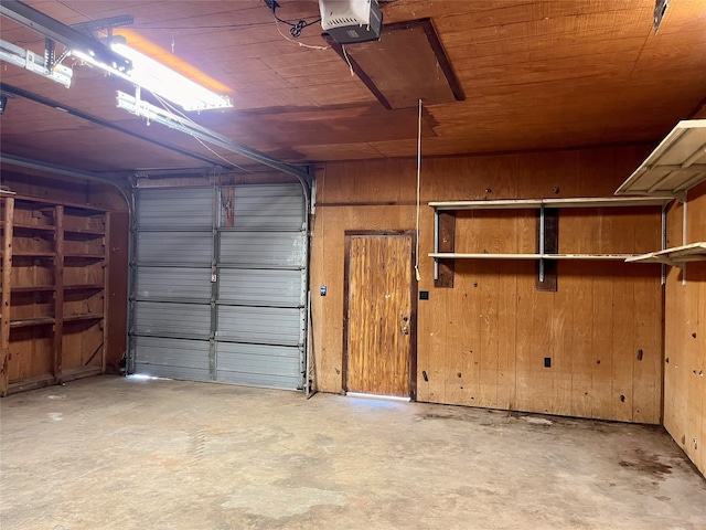 garage featuring wood ceiling, a garage door opener, and wood walls