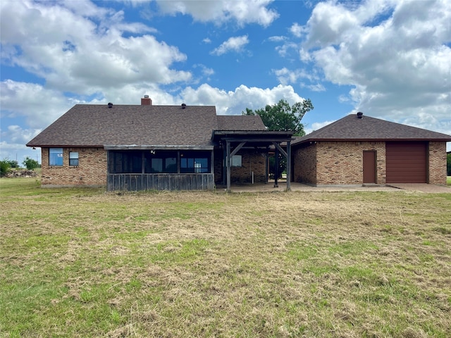 back of property with a sunroom, a garage, and a lawn