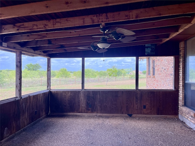 unfurnished sunroom with ceiling fan and beam ceiling