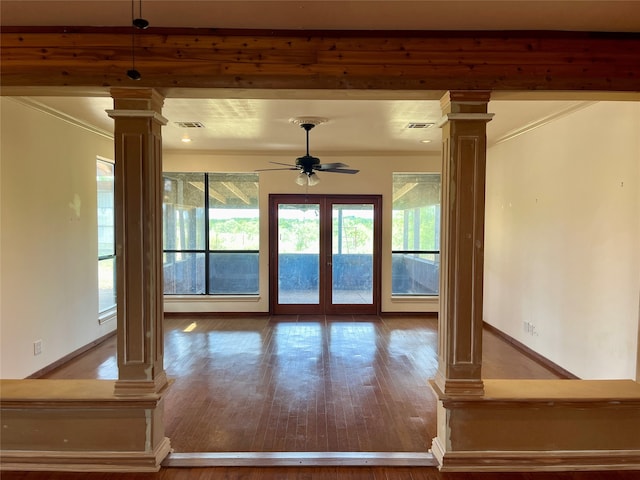 interior space featuring ornate columns, wood-type flooring, ceiling fan, and crown molding