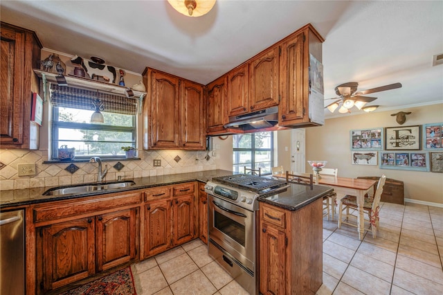 kitchen with stainless steel appliances, kitchen peninsula, tasteful backsplash, and sink