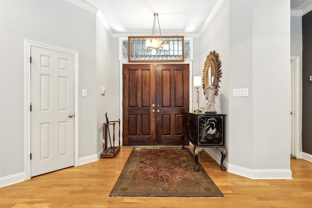 foyer featuring light wood-type flooring and ornamental molding