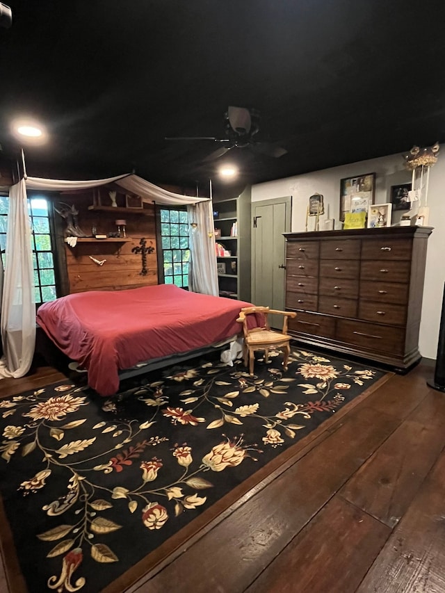 bedroom with ceiling fan, hardwood / wood-style flooring, and wood walls