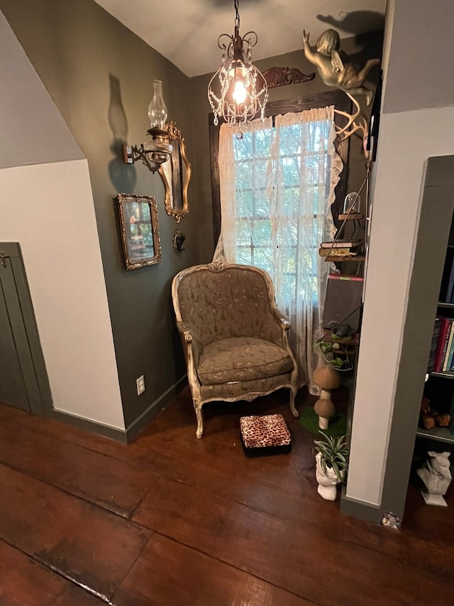 living area with dark wood-type flooring and a chandelier