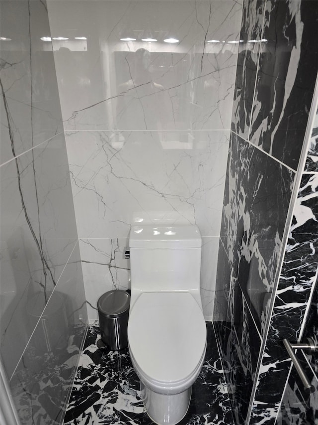 bathroom featuring tile walls, toilet, and tile patterned flooring