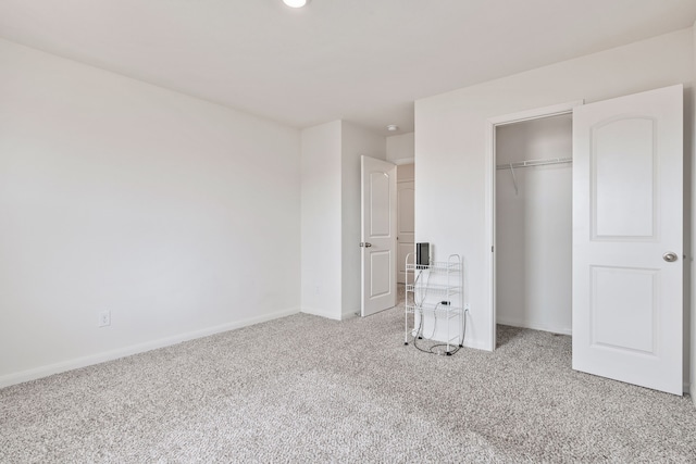 unfurnished bedroom with light colored carpet and a closet