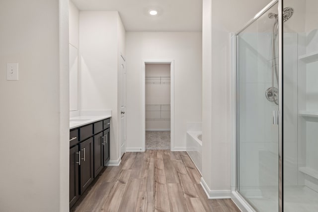 bathroom with hardwood / wood-style flooring, vanity, and separate shower and tub