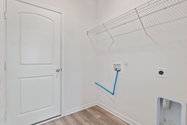 clothes washing area with hookup for an electric dryer, hookup for a gas dryer, light hardwood / wood-style floors, and hookup for a washing machine