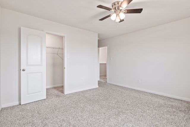 unfurnished bedroom featuring carpet, a closet, a spacious closet, and ceiling fan