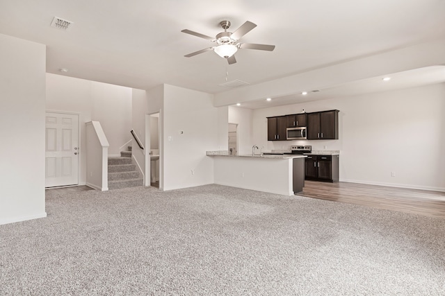 unfurnished living room with ceiling fan and carpet floors