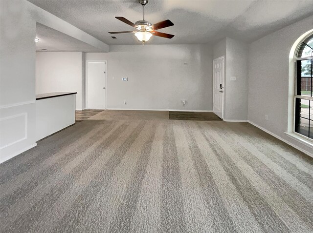 carpeted empty room with ceiling fan and a textured ceiling