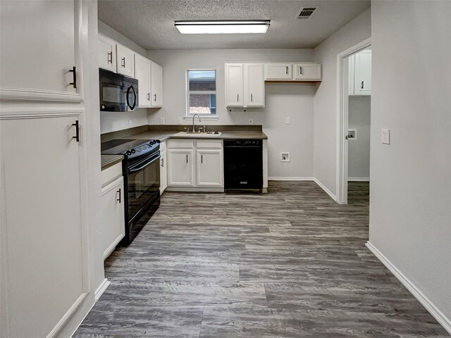 kitchen with a textured ceiling, black appliances, sink, white cabinetry, and dark hardwood / wood-style floors