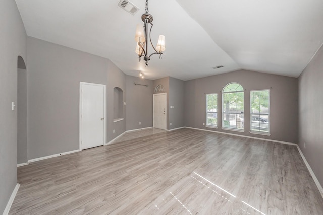 unfurnished room featuring vaulted ceiling, a chandelier, and light hardwood / wood-style floors