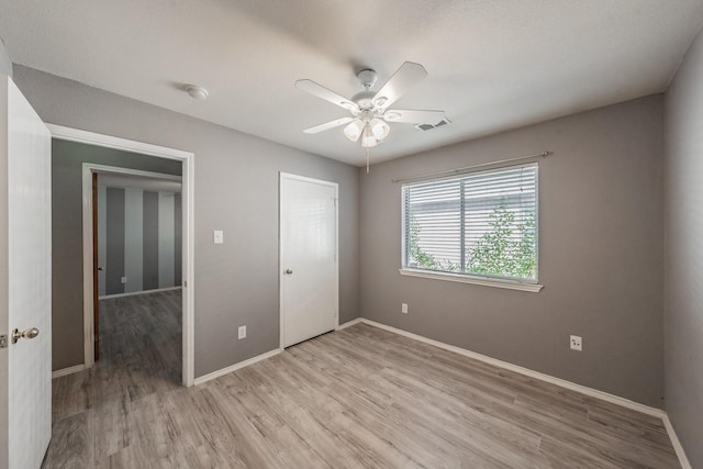 unfurnished bedroom with ceiling fan and light wood-type flooring