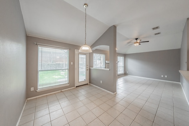 tiled empty room featuring a healthy amount of sunlight, vaulted ceiling, and ceiling fan