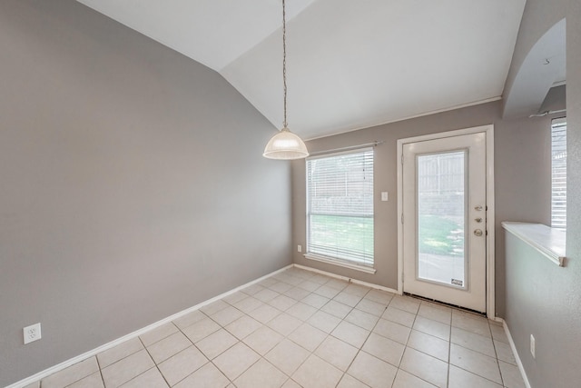 unfurnished dining area featuring vaulted ceiling and light tile patterned flooring