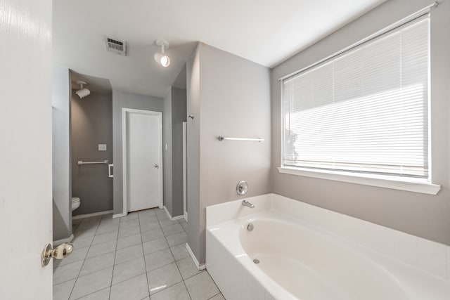 bathroom featuring tile patterned flooring, toilet, and a bathtub