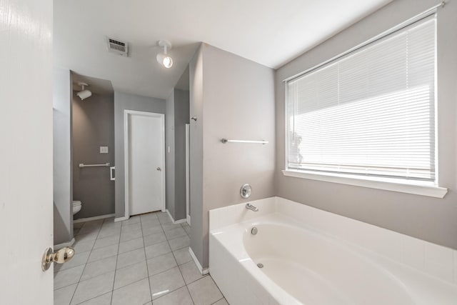 bathroom with tile patterned flooring, toilet, and a bathing tub