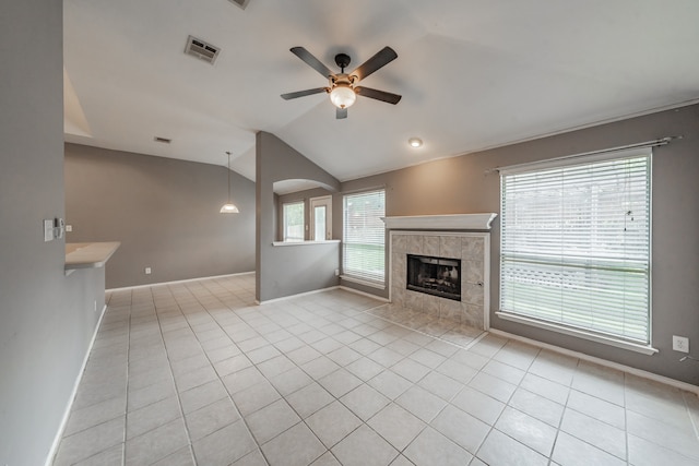 unfurnished living room featuring light tile patterned flooring, a tiled fireplace, ceiling fan, and lofted ceiling