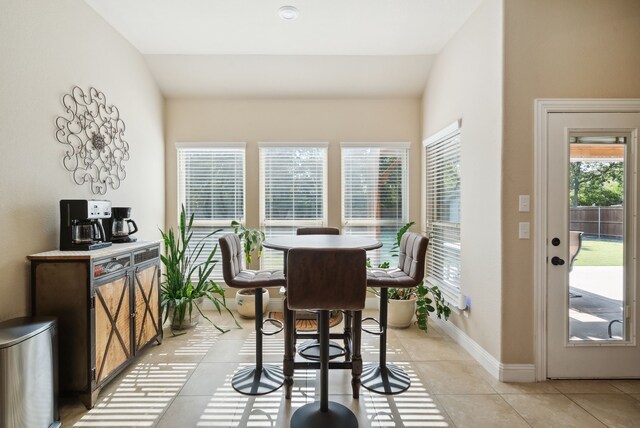 tiled dining room with lofted ceiling