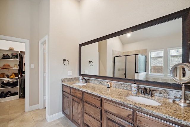 bathroom with lofted ceiling, tile patterned flooring, walk in shower, and double vanity