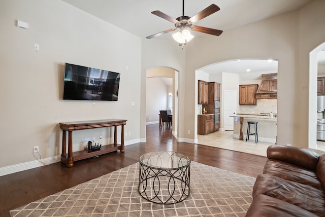 living room with light tile patterned flooring, a high ceiling, and ceiling fan