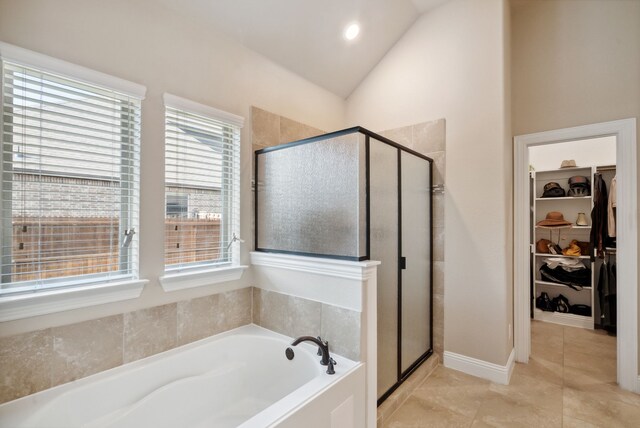 bathroom featuring independent shower and bath, lofted ceiling, and tile patterned floors