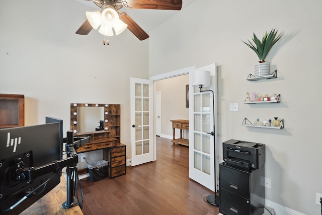 home office featuring ceiling fan, french doors, a towering ceiling, and dark wood-type flooring