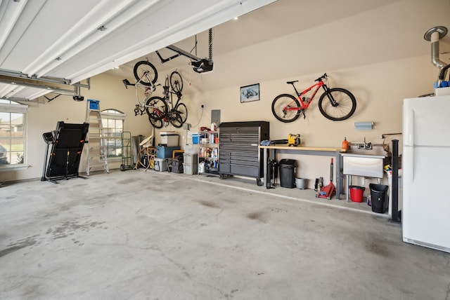 garage with white fridge, a workshop area, and a garage door opener