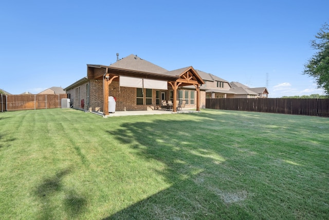 rear view of property with a lawn and a patio area