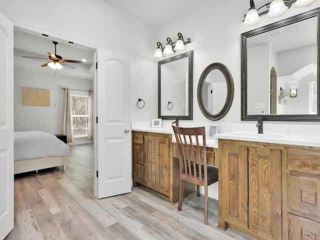 bathroom featuring ceiling fan, hardwood / wood-style floors, and double vanity