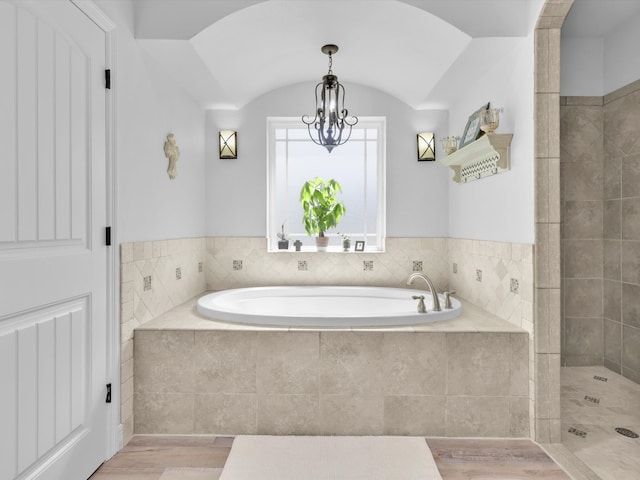 bathroom featuring lofted ceiling, wood-type flooring, a chandelier, and independent shower and bath