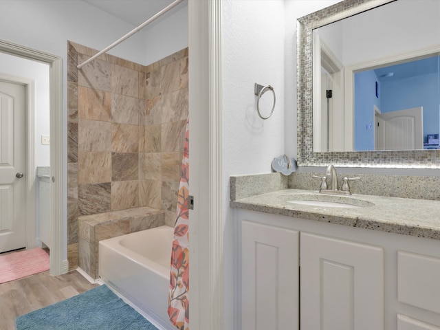 bathroom with hardwood / wood-style flooring, vanity, and shower / tub combo with curtain