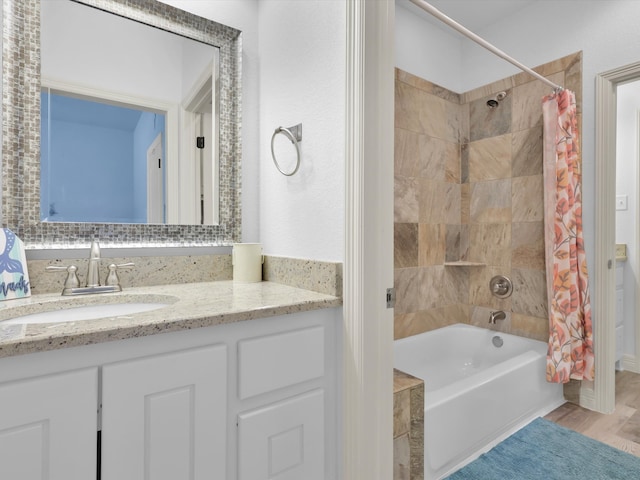 bathroom featuring wood-type flooring, shower / bathtub combination with curtain, and vanity