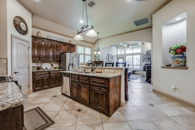 kitchen featuring appliances with stainless steel finishes, a wealth of natural light, ceiling fan, and an island with sink