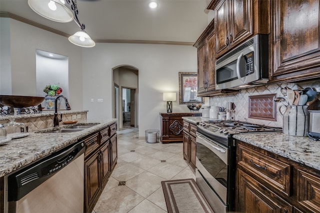 kitchen with light tile patterned floors, backsplash, light stone countertops, appliances with stainless steel finishes, and sink