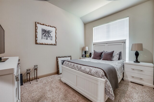 bedroom with light carpet and vaulted ceiling