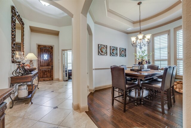 dining room with a chandelier, wood-type flooring, a wealth of natural light, and a tray ceiling