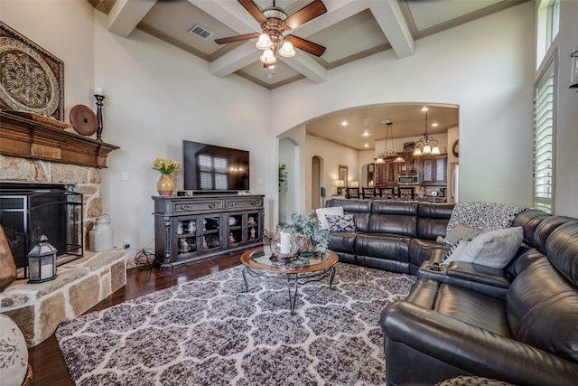 living room with ceiling fan with notable chandelier, beamed ceiling, coffered ceiling, hardwood / wood-style floors, and a fireplace