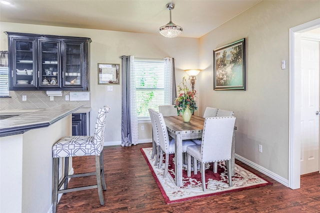 dining area with dark wood-type flooring and baseboards