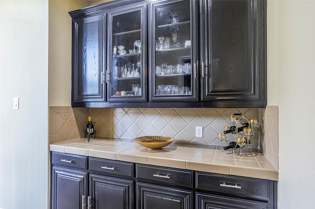 bar with tile countertops and tasteful backsplash