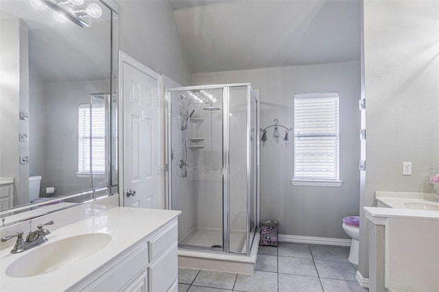 full bath with a stall shower, toilet, tile patterned floors, a sink, and two vanities