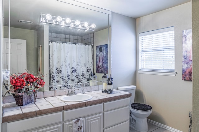 bathroom featuring vanity, toilet, and tile patterned flooring