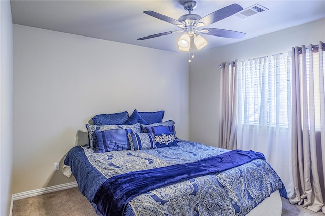 carpeted bedroom featuring multiple windows and ceiling fan