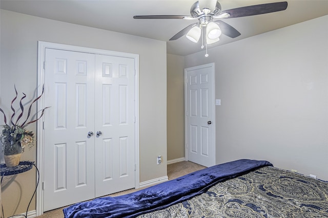 carpeted bedroom with ceiling fan and a closet